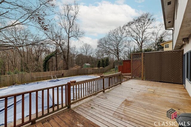 wooden terrace featuring a fenced backyard and a fenced in pool