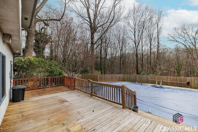 wooden deck featuring a fenced backyard and a fenced in pool