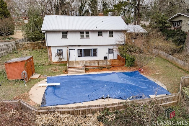 view of swimming pool featuring a fenced backyard, a diving board, a fenced in pool, and a wooden deck