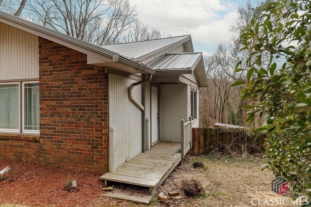 exterior space with metal roof and brick siding