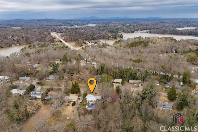 drone / aerial view featuring a forest view and a water view