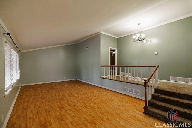 interior space with wood finished floors, visible vents, stairway, and an inviting chandelier