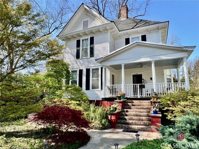 view of front of house featuring covered porch and a chimney