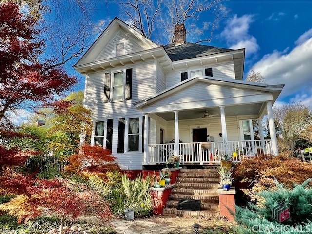 view of front of house featuring a porch, stairway, a chimney, and a ceiling fan