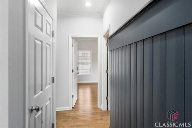 hallway with light wood-style flooring, ornamental molding, baseboards, and recessed lighting