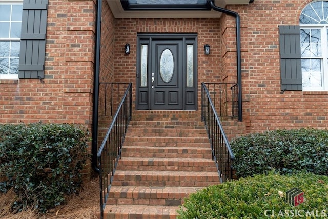 entrance to property featuring brick siding