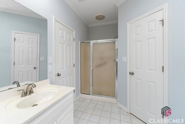 bathroom with a stall shower, tile patterned flooring, crown molding, and vanity