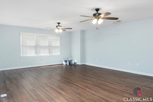 unfurnished room featuring visible vents, baseboards, dark wood finished floors, and a ceiling fan