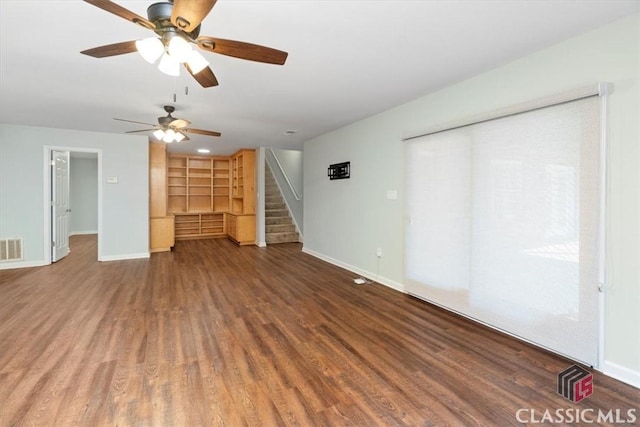 unfurnished living room featuring wood finished floors, visible vents, baseboards, and stairs