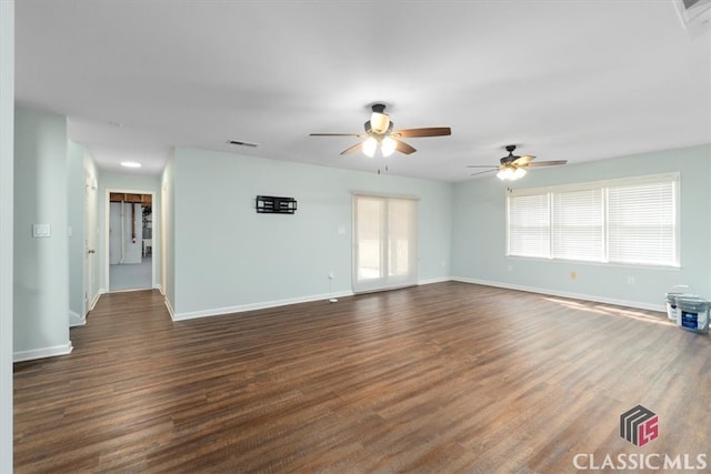 unfurnished living room featuring dark wood-style floors, visible vents, and baseboards