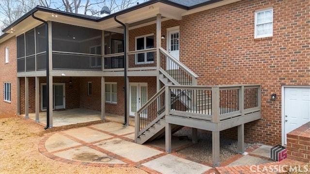 back of house featuring a sunroom, a patio area, brick siding, and stairway