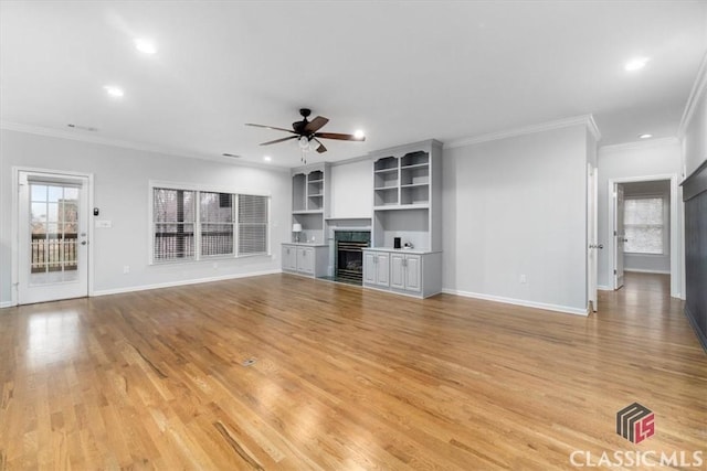 unfurnished living room featuring a fireplace, light wood-style flooring, baseboards, and ceiling fan