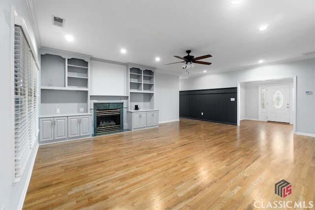 unfurnished living room featuring crown molding, a fireplace, a ceiling fan, and recessed lighting