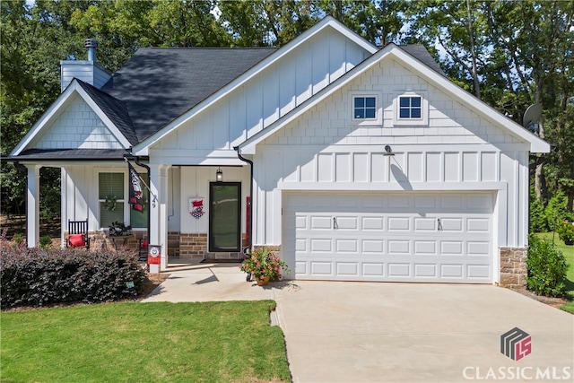 view of front of house featuring an attached garage, driveway, a chimney, and board and batten siding