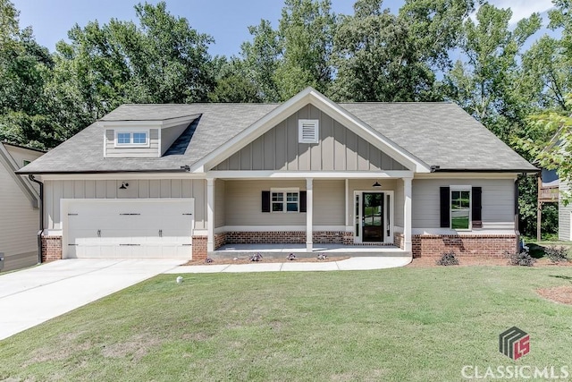 view of front of property featuring brick siding, board and batten siding, a front yard, a garage, and driveway