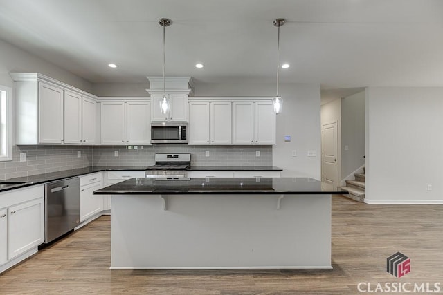 kitchen with light wood-style flooring, appliances with stainless steel finishes, and white cabinets