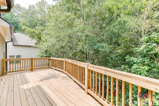 wooden terrace featuring a forest view