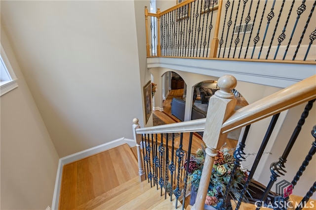 stairway with wood finished floors and baseboards