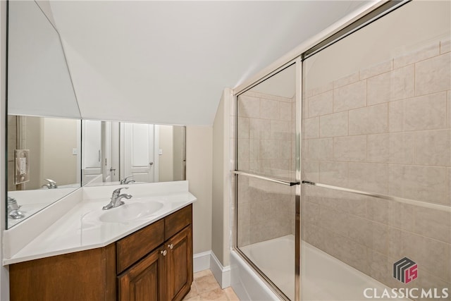 bathroom featuring enclosed tub / shower combo, lofted ceiling, and vanity