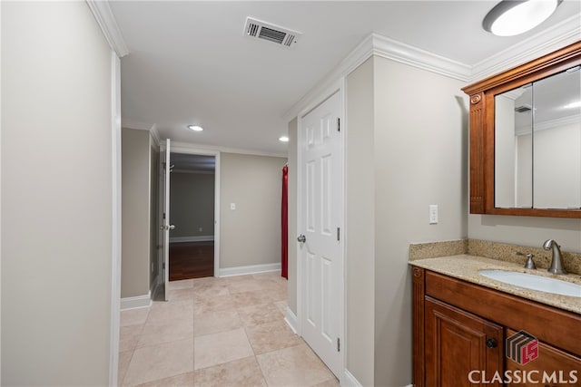 bathroom with baseboards, visible vents, and crown molding