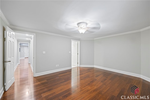 spare room featuring wood-type flooring, baseboards, and crown molding