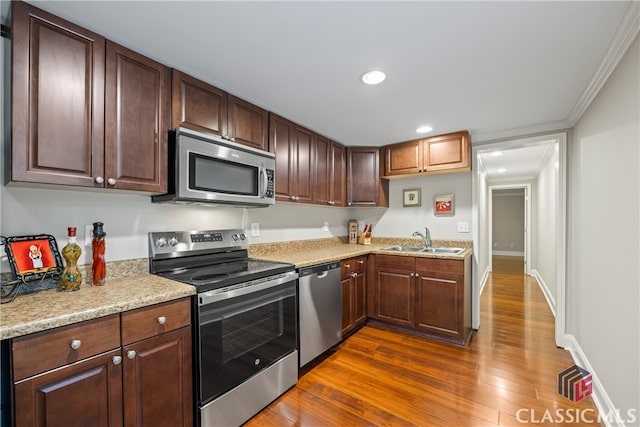 kitchen with dark wood-style floors, crown molding, stainless steel appliances, recessed lighting, and a sink