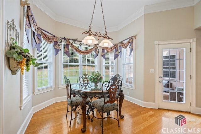 dining space with crown molding, baseboards, and light wood-style floors