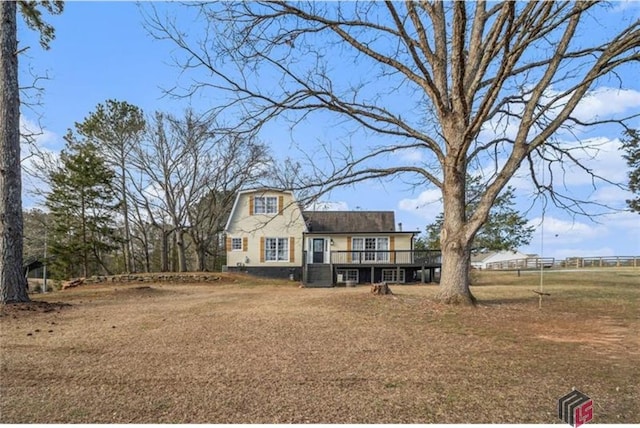 view of front facade with a deck and a gambrel roof