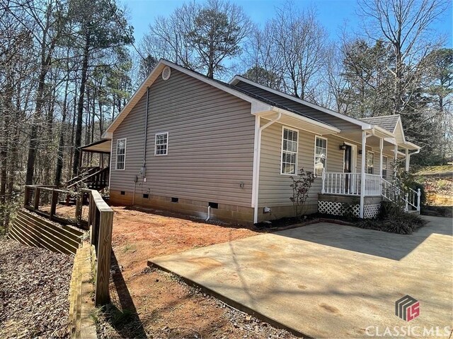 view of side of property featuring crawl space and a porch