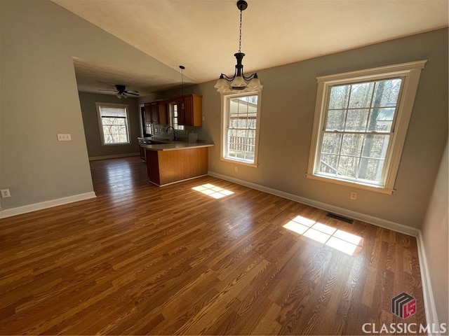 interior space with lofted ceiling, open floor plan, visible vents, and dark wood-style flooring