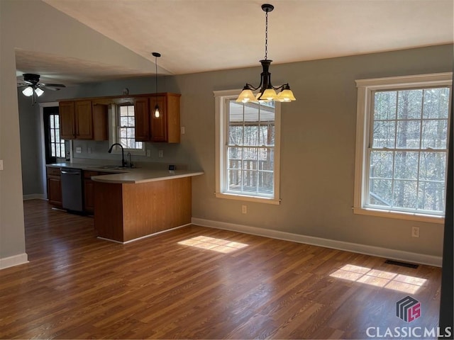 kitchen with visible vents, dishwashing machine, a peninsula, brown cabinetry, and a sink