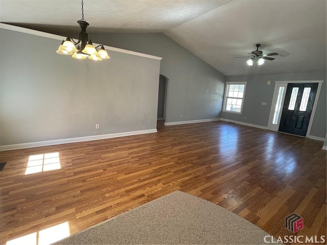 unfurnished living room with baseboards, lofted ceiling, arched walkways, dark wood-style flooring, and ceiling fan with notable chandelier