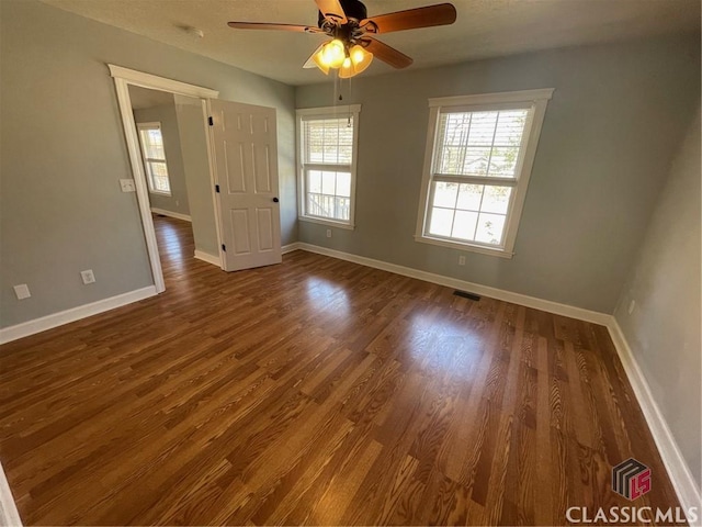 unfurnished room with visible vents, a ceiling fan, baseboards, and wood finished floors