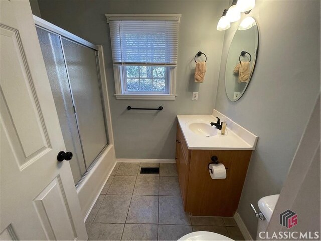 bathroom with tile patterned floors, baseboards, toilet, and vanity