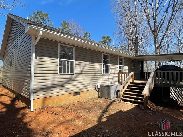 rear view of house featuring crawl space, central air condition unit, a wooden deck, and stairs