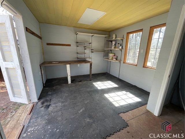 interior space with wood ceiling and concrete block wall