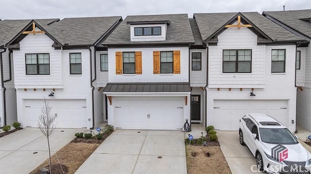 townhome / multi-family property featuring concrete driveway and a garage