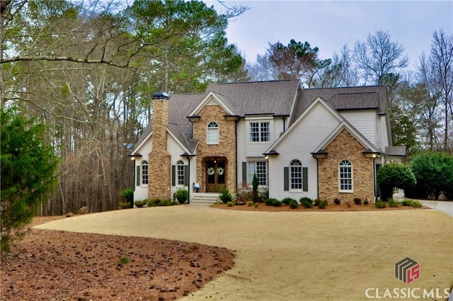 view of front of house with a chimney and a shingled roof