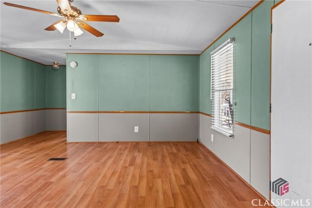 spare room with lofted ceiling, wood finished floors, and ceiling fan