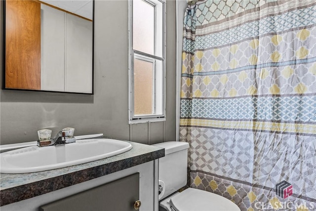 bathroom with vanity, curtained shower, and toilet