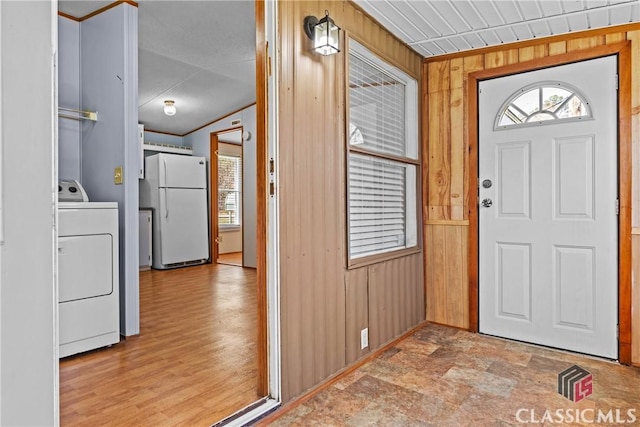 foyer with washer / dryer, wood finished floors, and wood walls