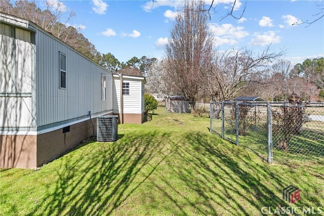 view of yard featuring central AC unit and fence