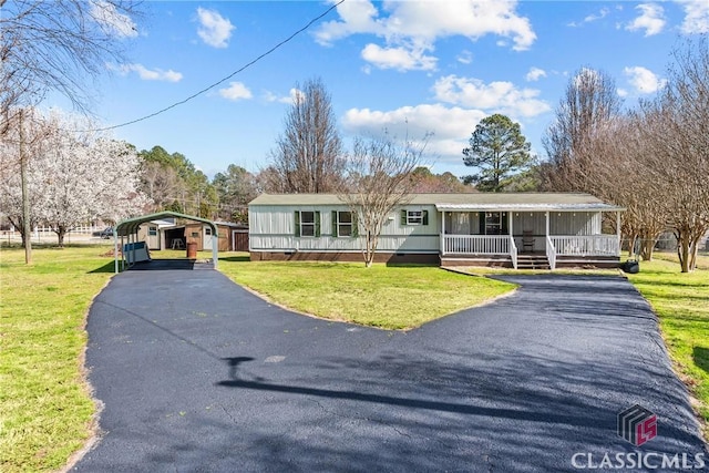 view of front of house featuring a detached carport, a front yard, driveway, covered porch, and crawl space