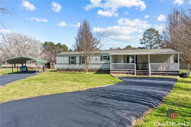 manufactured / mobile home featuring a front lawn, driveway, covered porch, crawl space, and a carport