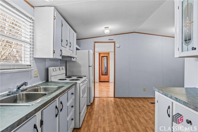 kitchen with dark countertops, lofted ceiling, light wood-style floors, white range with electric stovetop, and a sink