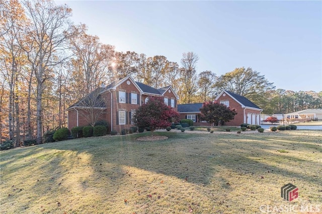 view of front of house featuring brick siding, an attached garage, and a front lawn