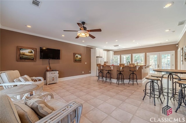 living area featuring a ceiling fan, baseboards, ornamental molding, visible vents, and recessed lighting