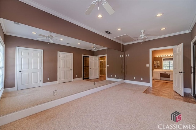 interior space with attic access, light carpet, baseboards, ceiling fan, and ornamental molding