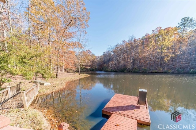 view of dock featuring a forest view and a water view