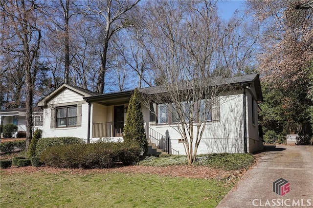 view of front of home featuring brick siding and a front lawn